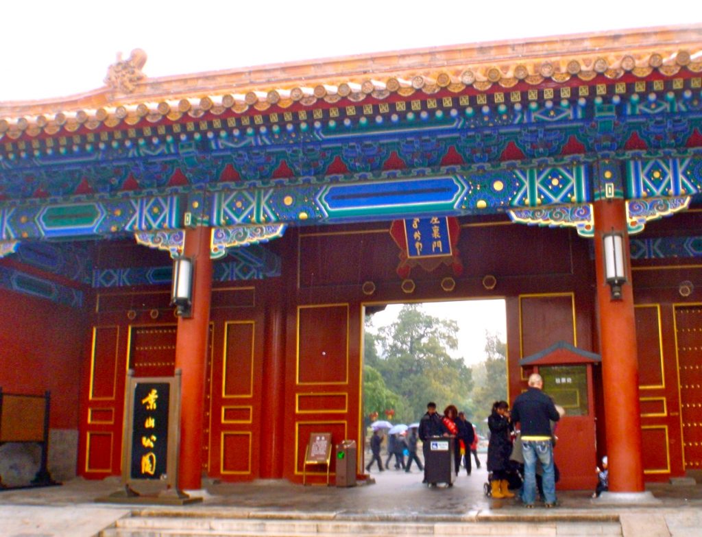 En stor röd dörr öppnas in till Jingshanparken i Peking