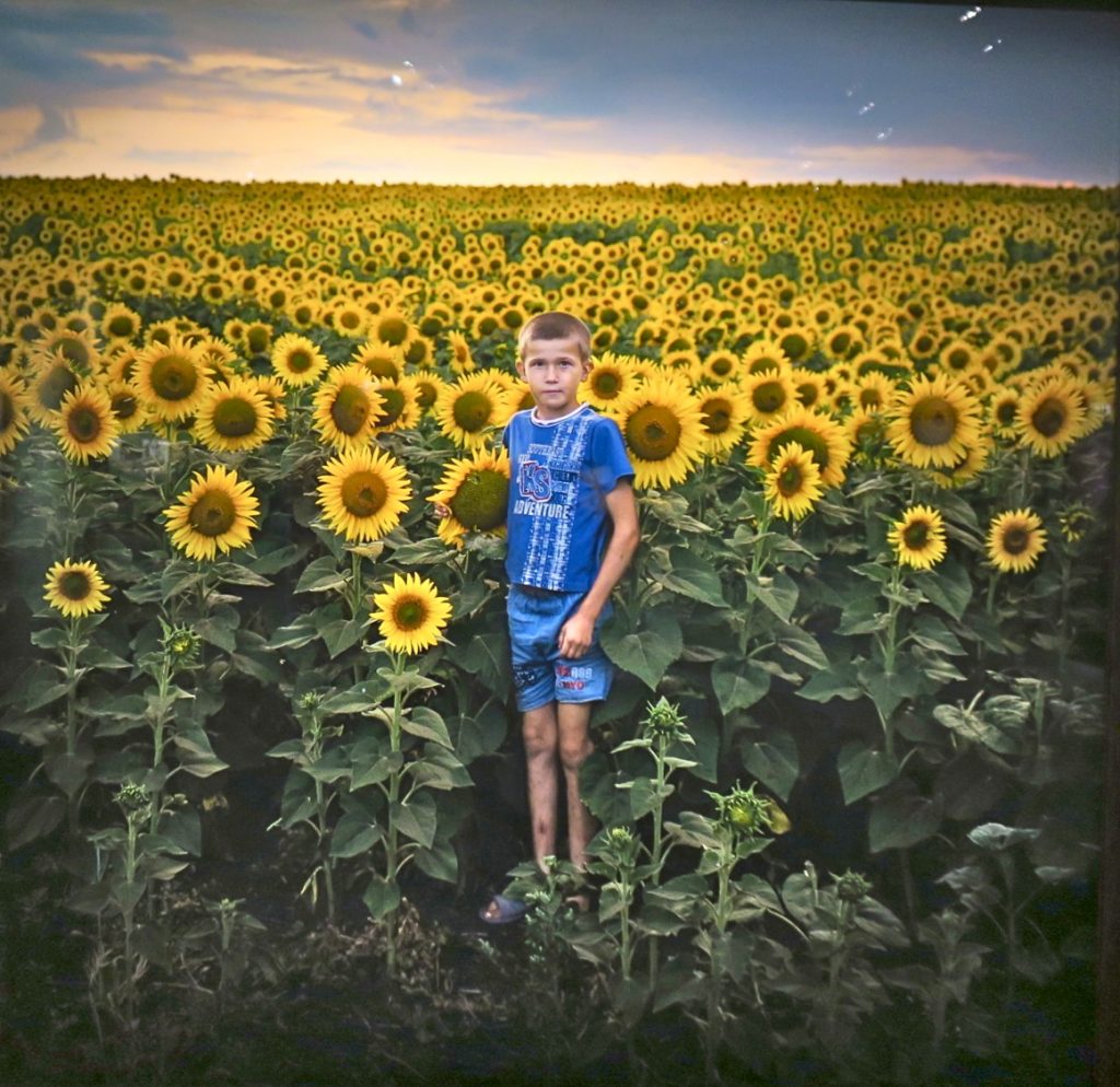 En pojke i fokus på ett solrosfält i Moldavien. Bilden igår i Åsa Sjöströms utställning, Silent Land" på Fotografiska i Stockholm 