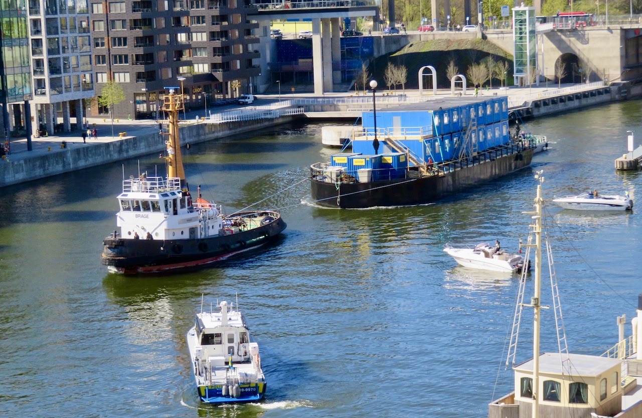 Södermalm Hammarbykanalen- En tittt från balkongen samtidigt som jag ordnar med blommorna. Här är ett antal båtar på väg in mot Hammarbyslussen. Både fritidsbåtar och andra.