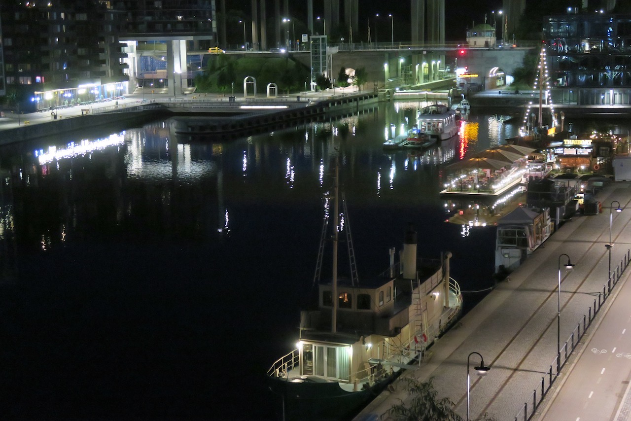 Stockholm. Södermalm. Norra Hammarbyhamnen. Speglingarna i kanalen har nu i mörkret blivit än mer framträdande äbn för någon timme sedan. 